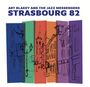 Text: ART BLAKEY AND THE JAZZ MESSENGERS, STRASBOURG 82. Illustration: Skizze einer Stadt mit Kirchen und Gebäuden in Farbblöcken.
