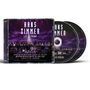 Cover mit "Hans Zimmer Live in Prague", Orchester auf Bühne, zwei CDs im Hintergrund.