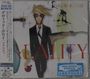 „DAVID BOWIE“, „REALITY“, Illustration: Figur im Anzug mit blonden Haaren, abstrakte Kunst im Hintergrund.
