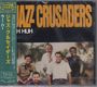 „JAZZ CRUSADERS“ in großen, orangenen Buchstaben, darunter eine Gruppe von fünf lächelnden Männern vor Palmen. Links Fließtext auf Japanisch.