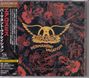 Japanischer und englischer Text, "Aerosmith" und "Permanent Vacation". Buntes Hintergrundmuster aus Blumen und Spielkarten.