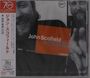 Text links: "ジョン・スコフィールド A GO GO +2". In der Mitte "John Scofield A GO GO". Schwarz-weißes Foto eines Mannes als Hintergrund.