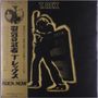 Text: "T. Rex", japanische Schriftzeichen, "Rock Now". Ein Mann in Silhouette spielt Gitarre vor einem Verstärker.
