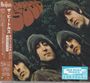 "Rubber Soul" in großer Schrift. Vier Männer mit langen Haaren in schräger Perspektive. Japanische Schriftzeichen links.