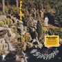 „Parliament" in gelber Schrift vertikal, „osmium deluxe" in einem gelben Kasten. Menschen stehen auf Felsen in einem Garten.