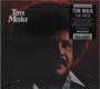 Oben links "Tim Maia". Rechts schwarzes Etikett: Details über das 1977er Album von Tim Maia. Dunkles Porträt eines Mannes.