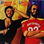 "Robson Jorge & Lincoln Olivetti" oben. Zwei Männer, einer im Anzug, einer im roten Shirt mit Aufdruck "Crazy Shirts 82".