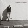 Text: "Wendy James, I Came Here to Blow Minds". Eine Person lehnt an einer weißen Wand, beleuchtet von der Sonne.