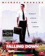 "Falling Down" in weißem Text vor einem Mann mit Krawatte und Aktentasche, der entschlossen in die Ferne schaut.
