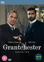 Text: "Robson Green, Rishi Nair, Grantchester, Series Ten." Zwei Männer in Anzügen, einer als Priester, vor Kirchenfenster.