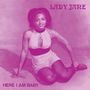 Text: "LADY JANE" oben und "HERE I AM BABY" unten. Eine Frau in einem ärmellosen Outfit sitzt auf dem Boden.