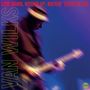 "LOW DOWN, WOUND UP, ROCKIN' TEXAS BLUES" in Rot, "VAN WILKS" in Grün, unscharfer Gitarrist in Bewegung, lila Hintergrund.