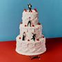 Drei-stöckige weiße Sahnetorte, verziert mit Kirschen. Auf der Torte Miniaturfiguren in schwarzen Anzügen.