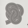 Linien in Schleifenform, schwarz-weiß, komplex verflochten; rechts unten "ESTEKA JOURNAL" als Textzeichen.