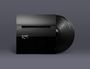Schwarze Vinyl-Schallplatte und Hülle mit dem Schriftzug "BE QUIET" über einem ruhigen, grauen See bei Sonnenaufgang.