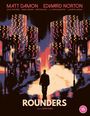 "ROUNDERS" und Schauspielernamen oben. Silhouette eines Menschen vor nächtlicher Stadt mit leuchtenden Hochhäusern.