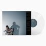 Der Text auf der Vinyl-Platte lautet "Black Gold Vinyl". Eine Frau sitzt auf einem Stuhl, ihr Schatten fällt an die Wand.