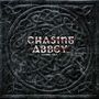 Text: "CHASING ABBEY CYBER CELT". Hintergrund: Dunkles, keltisches Knotenmuster.