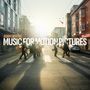 "ADAM GIBBONS MUSIC FOR MOTION PICTURES" steht auf einem belebten Straßenmotiv bei Sonnenuntergang mit Menschen.
