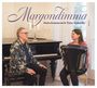 "Morgondimma" Maria Kalaniemi & Timo Alakotila. Ein Mann am Klavier und eine Frau mit Akkordeon lächeln einander an.