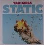 "Taxi Girls STATIC": Eine Hand drückt eine Zitrone, umgeben von spritzendem Wasser auf hellblauem Hintergrund.