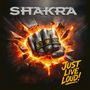 "SHAKRA" oben, "JUST LIVE LOUD!" rechts unten. Faust mit Ringen in Explosion, Ringe mit "XCV" und "XIV".