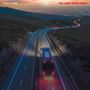 Text: "Paul Laine" und "The Long Road Back". Landschaft mit Straße, ein Bus fährt bei Sonnenuntergang. Lichter leuchten.
