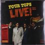 "FOUR TOPS LIVE! Deluxe Edition" steht groß über vier elegant gekleideten Männern, vor einem Gebäude mit Leuchtreklame.