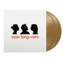 case/lang/veirs in orange, drei schwarze Silhouetten von Gesichtern im Profil darüber. Golden schimmernde Schallplatten.