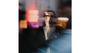 Ein unscharfes Farbfoto zeigt das verschwommene Gesicht eines Mannes mit Brille hinter einer Scheibe. Neonlichter im Hintergrund.