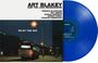 ART BLAKEY AND THE JAZZ MESSENGERS. Unter einem Nachtlicht hält ein Bus an der Straße, daneben eine blaue Vinyl-Schallplatte.