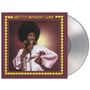"BETTY WRIGHT LIVE" steht oben in gelber Schrift. Eine Frau mit Afro hält ein Mikrofon, trägt ein rosa Outfit und lächelt.