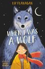"When I Was a Wolf" von Liz Flanagan. Illustration: Ein großer, sanfter Wolf und ein Mädchen mit rotem Schal vor einem Nachthimmel.