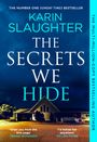 Oben steht "THE NUMBER ONE SUNDAY TIMES BESTSELLER", Titel: "THE SECRETS WE HIDE", unten Haus bei Nacht mit Beleuchtung.