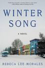 "WINTER SONG. A Novel. Rebeca Lee Morales." Verschneite Kleinstadtstraße mit bunten Häusern und einem Bus im Schnee.