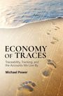 Text: "ECONOMY OF TRACES. Traceability, Tracking, and the Accounts We Live By. Michael Power." Fußspuren im Sand am Strand.