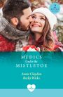 „Medics Under the Mistletoe“ von Annie Claydon und Becky Wicks. Ein Paar in Winterkleidung, der Mann küsst die Frau.