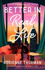 "Forever's More Than Just Fantasy. Better in Real Life. Adrienne Thurman. Zwei Menschen sitzen auf einem Sofa vor einer Stadtsilhouette."
