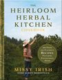 Titel: "The Heirloom Herbal Kitchen Cookbook". Frau pflückt im Garten Kräuter. Links ein goldener Buchrücken.