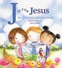 "J is for Jesus" in großen Buchstaben, drei Kinder betrachten ein Buch in einer farbenfrohen Landschaft aus Blumen.