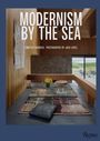 "MODERNISM BY THE SEA" steht in einem modern eingerichteten Raum mit hölzernen Wänden und Steinboden.