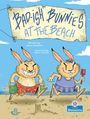 „Bad-ish Bunnies at the Beach“. Zwei fröhliche Hasen in Badekleidung am Strand, mit einem Sandburg-Hintergrund, illustriert.
