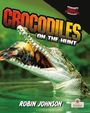 Der Text "Crocodiles on the Hunt, Robin Johnson". Ein Krokodil schnappt im Wasser ein Tier. Rechts unten ein Logo.