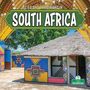 Text: "Life and Traditions in South Africa." Traditionelle Hütte mit bunten Mustern, Strohdach, Bäume im Hintergrund.