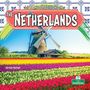 „LIFE AND TRADITIONS IN THE NETHERLANDS“, Arthur Yazdani. Eine Windmühle hinter bunten Tulpenfeldern.