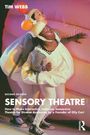 "Tim Webb: Sensory Theatre. Zwei Personen in weißen Kostümen auf einer Bühne, Hintergrund in Rosa."