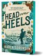 "HEAD over HEELS" ist der Titel. Naturkulisse mit einem Paar. Blumen und ein Schachfigur-Element sind zu sehen.