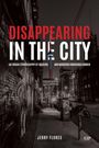 "DISAPPEARING IN THE CITY" von Jerry Flores. Schwarz-weiß Straßenansicht bei Nacht mit Motorrädern und Graffiti.