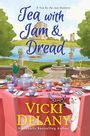 "Tea with Jam & Dread" und "Vicki Delany" sind im Vordergrund. Ein Tisch ist gedeckt mit Tee, Gebäck und Blumen.
