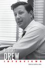 "ROBERT DREW INTERVIEWS" steht in großer Schrift. Ein Mann in Hemd sitzt vor einem Fenster mit Jalousien, schwarz-weiß.